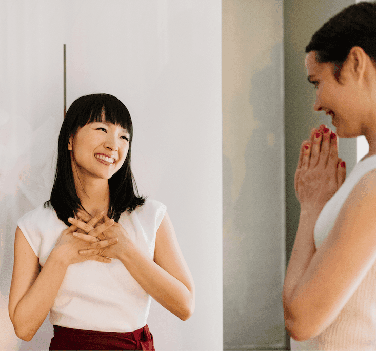 Marie Kondo smiling at a woman who is smiling back in gratitude